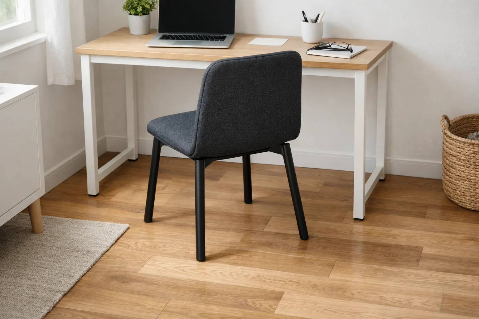 Chaise de bureau fixe reculée devant un bureau, avec un passage visible à côté.
