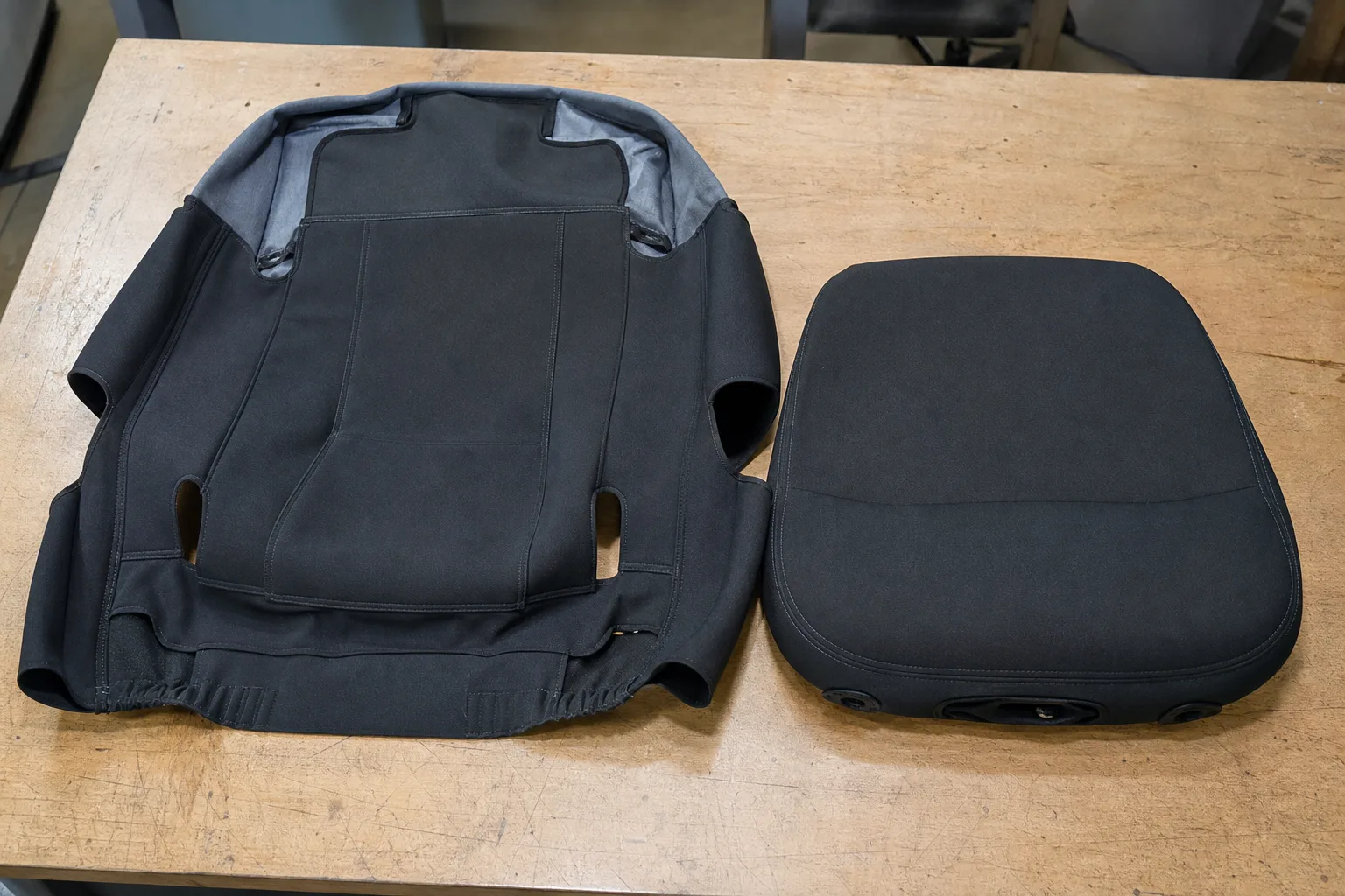 Housse de rechange étalée près d'un coussin d'assise de bureau, avec ses ouvertures et ses attaches visibles.